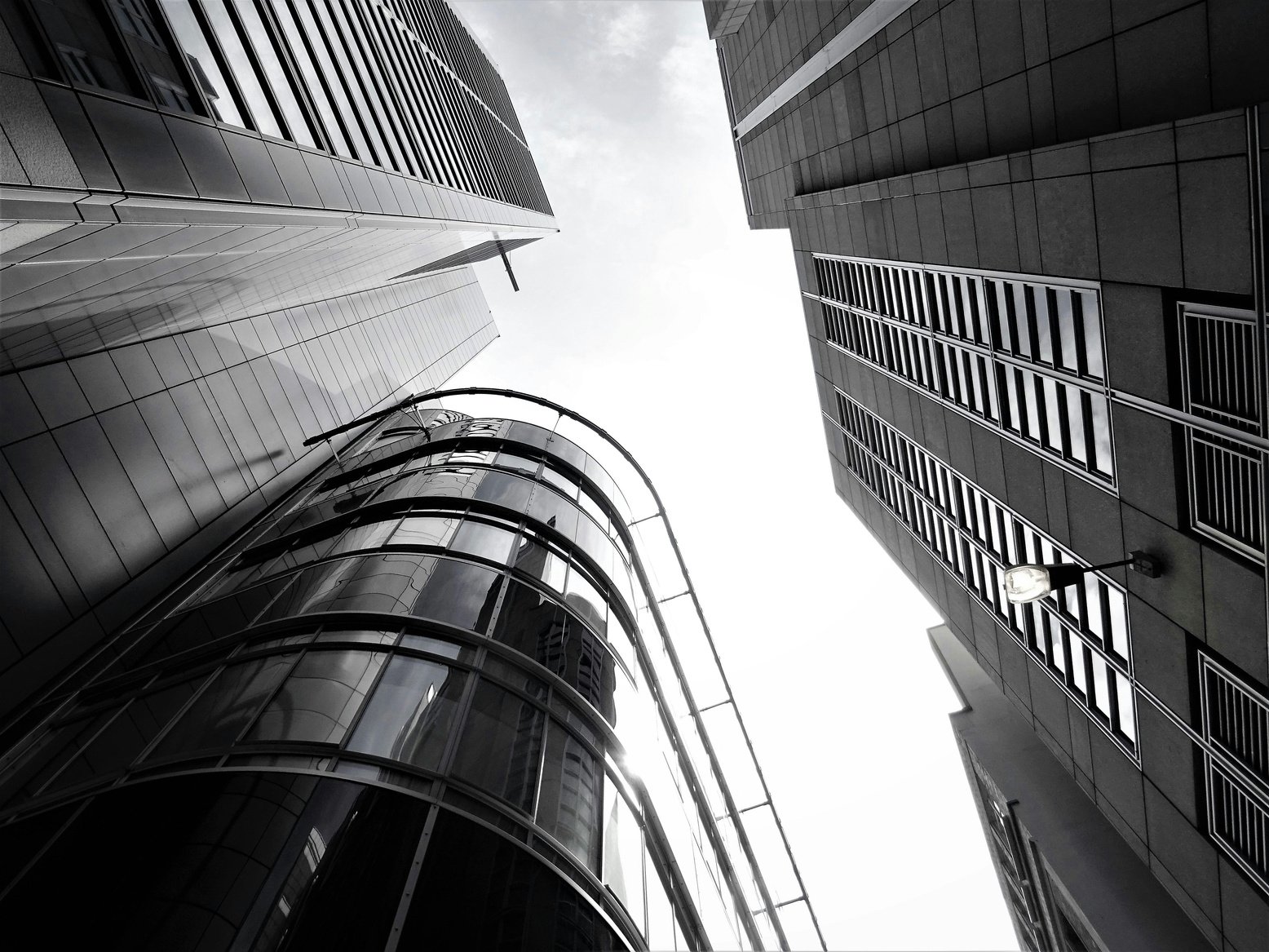 black and white photo of skyscrapers looking up at the sky with words excellence, integrity, advocacy 