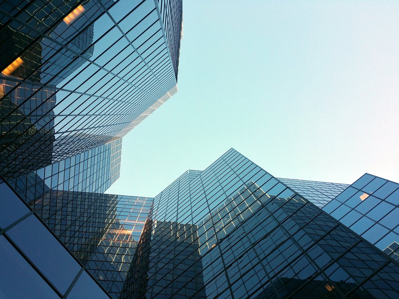 the sky is reflected in the windows of an office building with the words excellence, integrity and advocacy